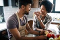 Beautiful young couple cooking healthy food together at home. Having fun in the kitchen. Royalty Free Stock Photo