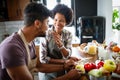 Beautiful young couple cooking healthy food together at home. Having fun in the kitchen. Royalty Free Stock Photo