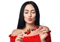 Having fun laughing brunette woman with bare shoulders holds a wooden skewer with berries and eats bites cherry isolated on white Royalty Free Stock Photo