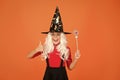 Having fun with magic. Little child in witch costume. Halloween party. Small girl in black witch hat. Autumn holiday