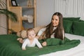 Having fun with mom and baby on the bed at home Royalty Free Stock Photo