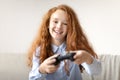 Young girl playing a video game with controller