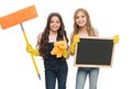 Having fun to work in team. Little schoolgirls enjoy doing cleaning work. Small cleaners in work gloves holding mop and