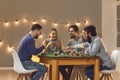 Happy young friends enjoying start of weekend, having drinks and playing game of poker Royalty Free Stock Photo