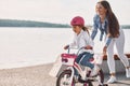 Having fun together. Mother with her young daughter is with bicycle outdoors together Royalty Free Stock Photo