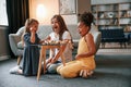 Having fun. A young woman with two girls is playing a wooden tower game indoors together Royalty Free Stock Photo