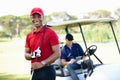 Having a great day out on the green. Portrait of a young man on a golf course with his friend waiting in the cart in the Royalty Free Stock Photo