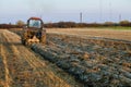 Having harvested the autumn field, the tractor ploughs it after it has been harvested