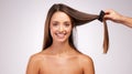 Having her hair styled. Studio portrait of an attractive young woman having her hair tended to backstage against a grey Royalty Free Stock Photo