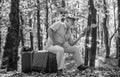 Having leisure to read more. Retired person read book in autumn nature. Old man read sitting on retro suitcase