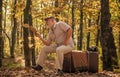 Having leisure to read more. Retired person read book in autumn nature. Old man read sitting on retro suitcase