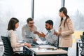 Having the meeting. Four people are working in the office together