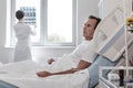 Exhausted man dreaming while lying in hospital bed Royalty Free Stock Photo