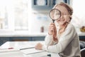 Playful little girl holding a magnifying glass