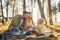 Having picnik. Happy family of father, mother and little daughter is in the forest Royalty Free Stock Photo