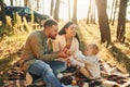 Having picnik. Happy family of father, mother and little daughter is in the forest Royalty Free Stock Photo