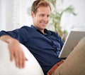 Having a really relaxed day...a handsome man using his tablet while sitting on the sofa at home. Royalty Free Stock Photo