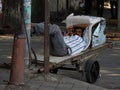 Having a rest in his tricycle on the busy streets of Mumbai India