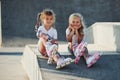 Having a rest. On the ramp for extreme sports. Two little girls with roller skates outdoors have fun Royalty Free Stock Photo