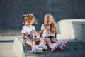 Having a rest. On the ramp for extreme sports. Two little girls with roller skates outdoors have fun Royalty Free Stock Photo