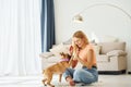 Having a rest. Woman with pug dog is at home at daytime Royalty Free Stock Photo