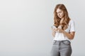 Having serious conversation in group chat. Portrait of focused attractive busy woman in glasses, standing half-turned