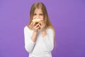 Having snacks. Child eat donut on violet background. Little girl with glazed ring doughnut on purple background. Kid Royalty Free Stock Photo