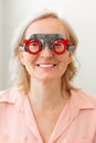 Beaming good-looking woman checking abilities of her vision with different lenses