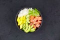 Hawaiian ahi, a diet meal with fish. Poke bowl of salmon, rice, avocado, cucumber, mango, herbs Royalty Free Stock Photo
