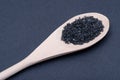 Hawaiian Black Lava Sea Salt in handmade wooden spoon on dark