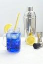 Hawaiian Blue Lagoon summer alcoholic cocktail with ice in glass jar. Bartender equipment shaker, jigger and muddler Royalty Free Stock Photo