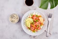 Poke bowl with salmon or tuna, rice, avocado, sesame seeds, micro greens and persimmon. Royalty Free Stock Photo