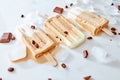 Vegan banana coffee creamy dairy free ice popsicles over ice and marble background with piece chocolate and coffee beans Royalty Free Stock Photo