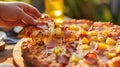 A Hawaiian pizza featuring pineapple and ham with hands reaching for a slice Royalty Free Stock Photo