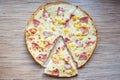 Hawaiian pizza with pineapple, sliced slice of pizza on a wooden background top view Royalty Free Stock Photo