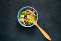 Salmon Poke Salad with spinach and basil. Homemade food. The concept of a tasty and healthy meal.Dark stone background.Copy space.