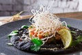 Hawaiian poke on black sesame flat cake. Modern restaurant food background