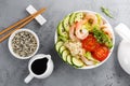 Hawaiian poke bowl with shrimps, rice and vegetables, healthy Buddha bowl with prawns, rice, avocado, cucumber, tomato and lettuce