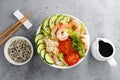 Hawaiian poke bowl with shrimps, rice and vegetables, healthy Buddha bowl with prawns, rice, avocado, cucumber, tomato and lettuce