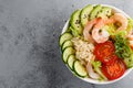 Hawaiian poke bowl with shrimps, rice and vegetables, healthy Buddha bowl with prawns, rice, avocado, cucumber, tomato and lettuce