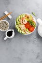 Hawaiian poke bowl with shrimps, rice and vegetables, healthy Buddha bowl with prawns, rice, avocado, cucumber, tomato and lettuce