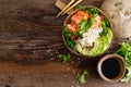 Hawaiian poke coconut bowl with grilled salmon fish, rice and avocado. Healthy food Royalty Free Stock Photo