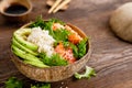 Hawaiian poke coconut bowl with grilled salmon fish, rice and avocado. Healthy food Royalty Free Stock Photo