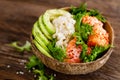 Hawaiian poke coconut bowl with grilled salmon fish, rice and avocado. Healthy food