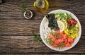 Hawaiian salmon fish poke bowl with rice, avocado, mango, tomato, sesame seeds and seaweeds. Royalty Free Stock Photo