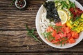 Hawaiian salmon fish poke bowl with rice, avocado, mango, tomato, sesame seeds and seaweeds. Royalty Free Stock Photo