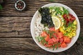 Hawaiian salmon fish poke bowl with rice, avocado, mango, tomato, sesame seeds and seaweeds. Royalty Free Stock Photo