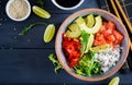 Hawaiian salmon fish poke bowl with rice, avocado, paprika, sesame seeds and lime Royalty Free Stock Photo