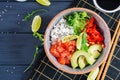 Hawaiian salmon fish poke bowl with rice, avocado, paprika, sesame seeds and lime Royalty Free Stock Photo