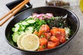 Hawaiian salmon fish poke bowl with rice, radish,cucumber, tomato, sesame seeds and seaweeds. Royalty Free Stock Photo